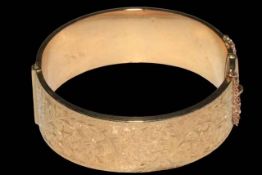 9 carat gold bangle, half engraved with scrolling foliage, 6.5cm across, boxed.