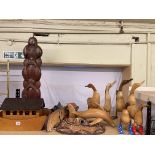 Collection of wooden sculptures including kissing ducks, tribal masks, etc.