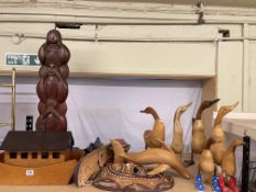 Collection of wooden sculptures including kissing ducks, tribal masks, etc.