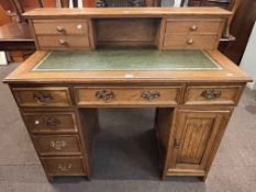 Oak six drawer pedestal desk with linen fold panel cupboard door, 77.5cm by 105.