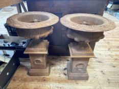 Pair cast rusted garden urns on stands, 63cm by 42cm diameter.