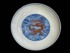 Chinese saucer dish with iron red dragon on blue ground, seal mark, 18cm.