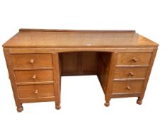 Robert Thompson of Kilburn 'Mouseman' adzed oak six drawer kneehole desk, 74.5cm by 137cm by 50cm.