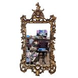 Large ornate gilt framed bevelled wall mirror, 152cm by 78cm.