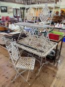 Metal lattice work design garden table and six folding chairs, table 153cm by 76cm.