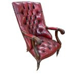 Red leather button back library chair on turned legs.