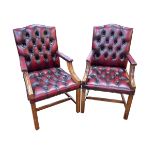 Pair deep buttoned ox blood leather armchairs.