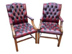 Pair deep buttoned ox blood leather armchairs.