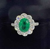 Impressive emerald and diamond cluster ring having oval approximately 2 carat emerald bordered with