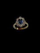 Sapphire and diamond cluster 18 carat gold ring, the oval sapphire bordered with eight diamonds,