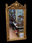 Rectangular gilt framed bevelled wall mirror, the central crest flanked by cherub musicians,