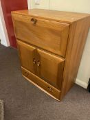 Ercol Windsor drinks cabinet, the fall front above two cupboard doors and base drawer, 102.