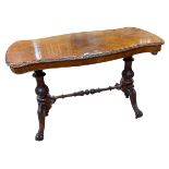 Victorian walnut centre table of serpentine form raised on two carved pedestals joined by turned