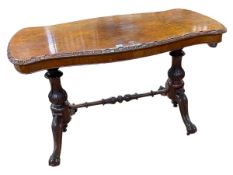 Victorian walnut centre table of serpentine form raised on two carved pedestals joined by turned