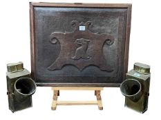 Carved oak panel and a pair of brass lamps.