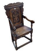 Carved oak panel back elbow chair.