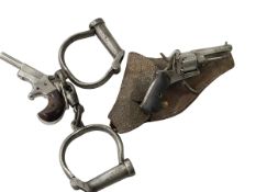 Two muff pistols and vintage handcuffs.