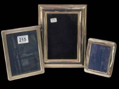 Three silver photograph frames, largest 20cm by 15cm.