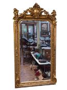 Rectangular gilt framed bevelled wall mirror, the central crest flanked by cherub musicians,