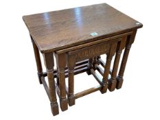 Oak nest of three tables raised on turned legs, largest 38cm by 58cm by 54cm.