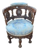 Victorian heavily carved oak round seated tub chair on six claw legs.