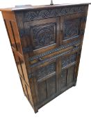 Carved oak cocktail cabinet having double cupboard doors above sliding shelf with larger double