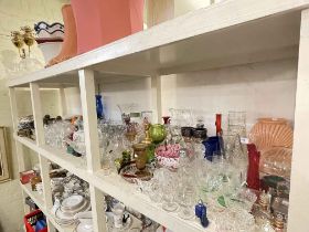Full shelf of coloured and clear glassware, cutlery, EP, etc.
