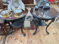 Pair circular mask decorated cast base pub tables, 74cm by 65cm diameter.