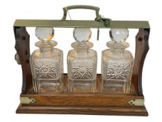 Oak and brass bound three bottle tantalus with key.