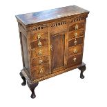 Small oak cabriole leg cabinet having central cupboard door flanked by ten drawers,