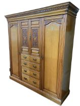 Victorian carved ash combination wardrobe having two central carved panel doors above four drawers