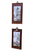 Pair of Chinese porcelain panels decorated with figures in mountainous landscapes, in wood frames.