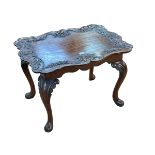 Mahogany shaped top low table having carved eagle head and floral border on cabriole legs,