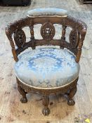 Victorian heavily carved oak round seated tub chair on six claw legs.
