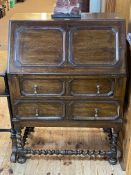 Jacobean style oak two drawer bureau on barley twist legs, 105cm by 75.5cm by 45cm.