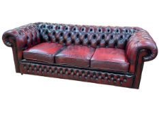 Ox blood buttoned leather three seater Chesterfield settee, 200cm by 66cm by 88cm.