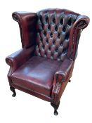 Thomas Lloyd ox blood buttoned leather wing armchair.