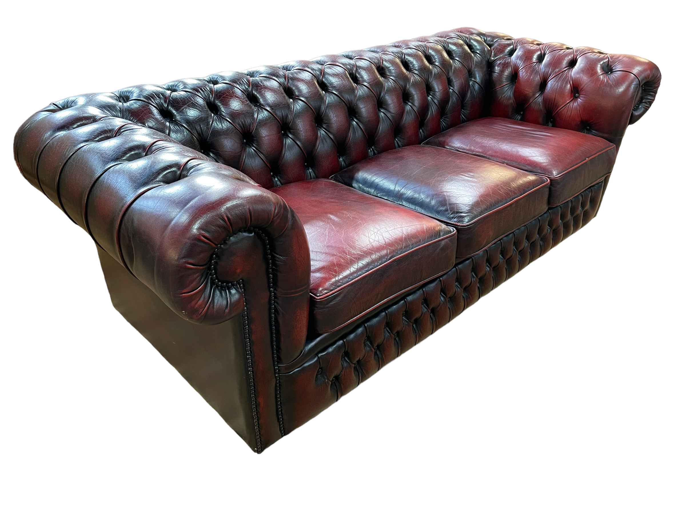 Ox blood buttoned leather three seater Chesterfield settee, 200cm by 66cm by 88cm.