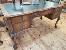 Early 20th Century mahogany five drawer writing desk on ball and claw legs, 76cm by 152cm by 83cm.