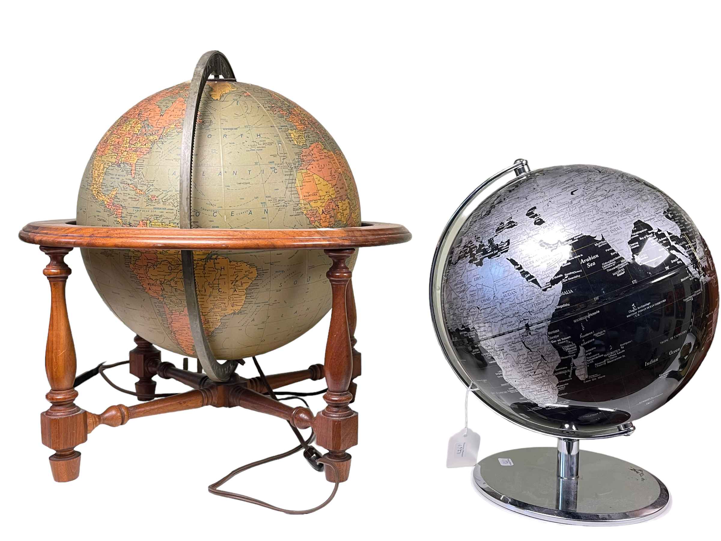 Illuminated globe on mahogany stand and black and silvered globe on chrome stand.