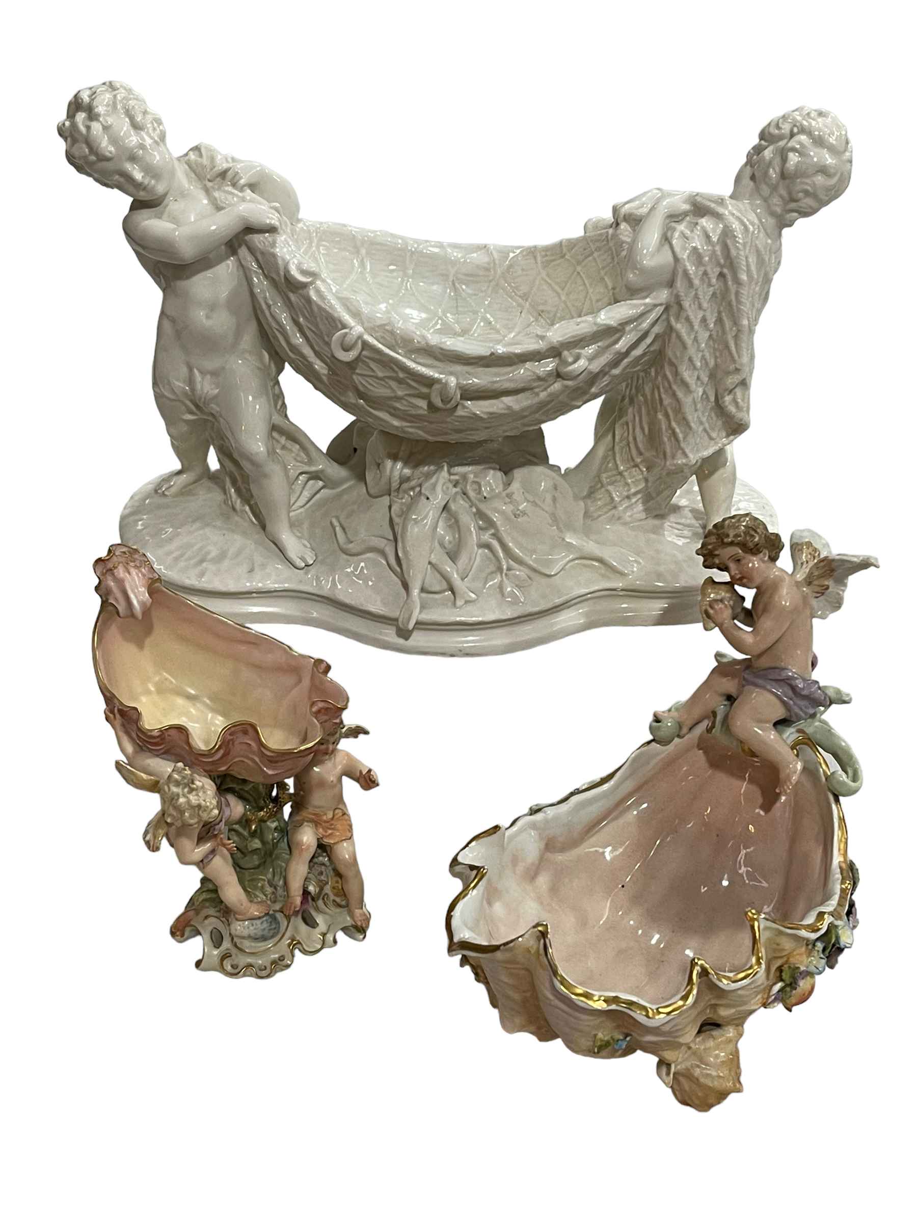 Blanche de Chine cherub centre piece, and two Continental cherub and shell vases (3).