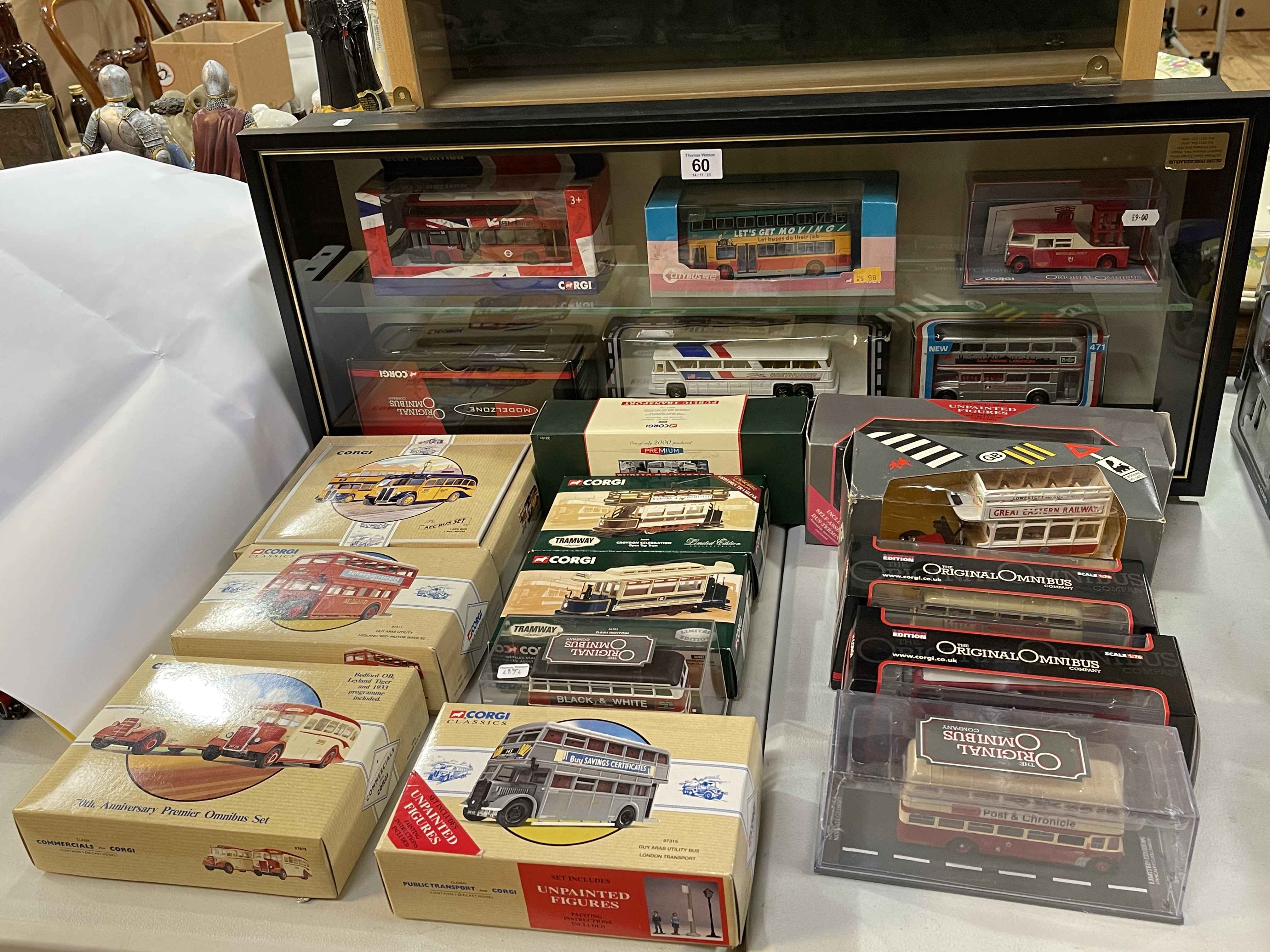 Collection of Corgi model buses and two model vehicle display cases.