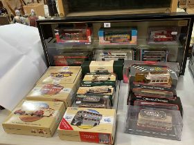 Collection of Corgi model buses and two model vehicle display cases.