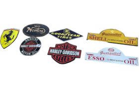 Seven cast metal motoring signs including Harley Davidson, Norton, Esso, etc.