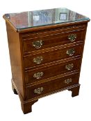 Ian Smith reproduction walnut crossbanded bachelors chest having plate glass top above a brush