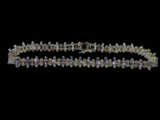 9 carat white gold tennis bracelet set with alternating blue stones and diamonds, 18.5cm.