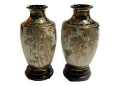 Pair of Satsuma vases decorated with flora and fauna on wood stands, 17cm.