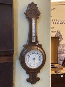 Carved oak aneroid barometer with enamelled dial, 87cm.
