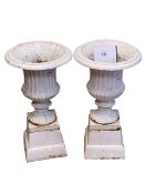 Pair small cast Campana style garden urns on stands, 50cm by 29cm diameter.