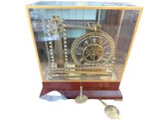 Brass Mystery Water Wheel Ball Bearing timepiece under glass case on rosewood base, 41.